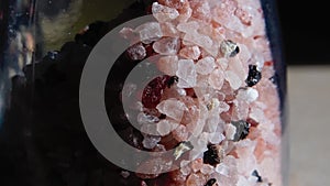 close-up of coarse Himalayan pink salt in a salt shaker in natural light