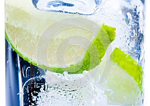 Close-up of cocktail glass with ice and lime slice isolated