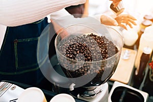 Close-up coffee beans inside Electric Coffee Grinder Grinding Machine. Coffee Mill Both Household And Business Machine.