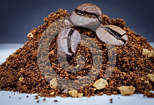 close up of coffee beans in a pile of ground coffee powder