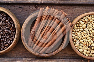 Close up of coffee beans in wooden bowl and cinnamon