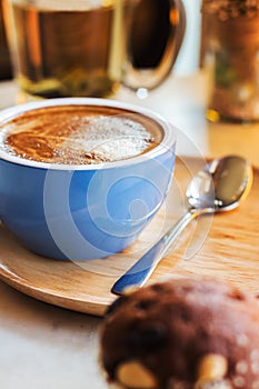 Close up coffee cup with steam on table in cafe.