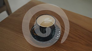 Close-up of coffee cup on table at a coffee shop. Morning coffee with steam in white cup.