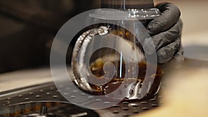 Close-up of coffee extraction in glass aero press by barista