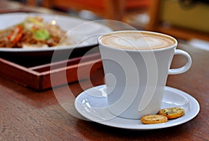 Close up coffee latte art with biscuits on the table.