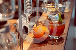 Close-up coffee mixed with orange juice in a clear glass Placed next to a large orange in the laboratory