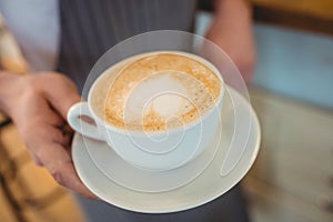 Close-up of coffee served by waitress at cafe