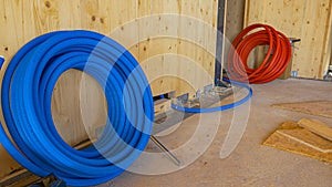 Da vicino bobina da blu gomma tubi è un lanciato fuori Venire di legno parete 