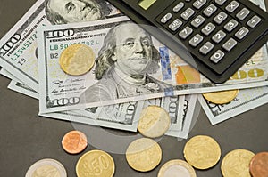 Close-up of coins on a background of dollars and a calculator. Business concept.