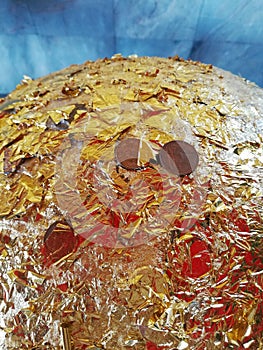 Close up of coins and gold leaf on the sacred marker sphere, Luuk Nimit