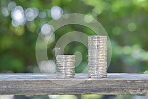 Close-up of the coins stack on the wooden table for a financial business presentation over nature background