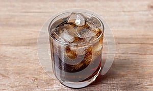 Close up cola and ice cube in clear glass
