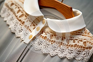 Close-up of the collar of the lace dress on a wooden hanger