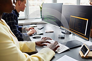 Colleagues writing codes on computers
