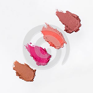 Close-up of a collection of colorful lipstick samples on a white background