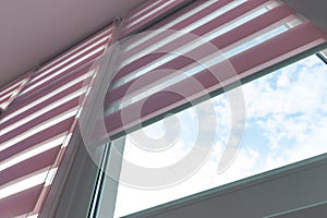 Close up of colored fabric roller blinds on window. Roll curtains