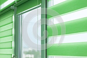 Close up of colored fabric roller blinds on window. Roll curtains