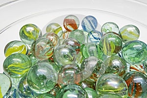 Close-up of colored glass marbles in a glass jar