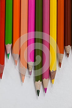 Close-up of colored pencils arranged in a wave pattern