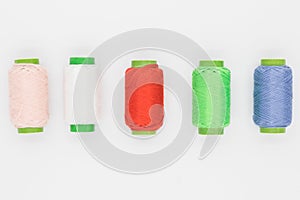 Colored spools of thread on a white background