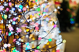 Close up colorful bulb lights on tree shape garland on the background of Various glowing Christmas lights in the shop. Holiday bac