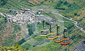 CLOSE UP: Colorful cable cars move above the old ski town in the French Alps. photo