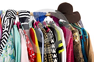 Close up on colorful clothes and hat on hangers in a store.