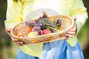 Close-up of colorful Easter eggs in a basket at child`s hands