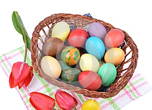 Close up of colorful Easter eggs in a basket and colorful tulip decorations