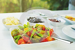 Close up Colorful fresh organic vegetable salad on white table. Peppers, tomato cheese