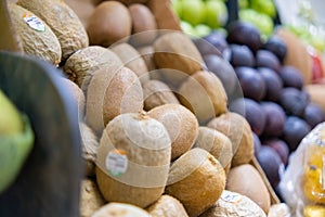 Close-up of colorful fruit stand with kiwis, plums, and more