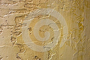 Close-up of colorful golden bronze plastered uneven stucco wall. Abstract texture, chaotic copy space background. Decorative