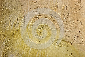 Close-up of colorful golden bronze plastered uneven stucco wall. Abstract texture, chaotic copy space background. Decorative