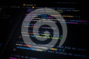 Close-up of colorful JavaScript and React source code on computer screen, showing socket connection and server communication for