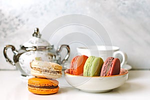 Close up of colorful macarons with cup and sugar bowl