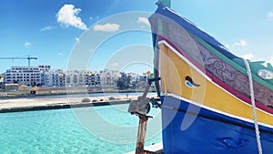 Close up of colorful Maltese boat with eye in Qawra bay. Maltese Luzzu fishing boat