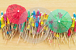 Close up colorful of many cocktail umbrellas on white wooden ba