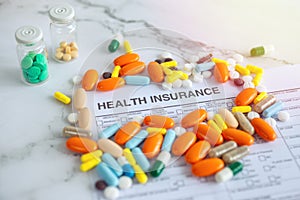 Close up of colorful medicine pills on insurance paper bill. Health care concept