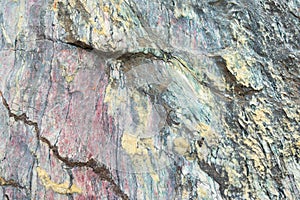 Close up of colorful rock surface, natural background, pattern and texture. Metamorphic white quartzite folded and fractured toget