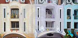 Close-up colorful shophouses painted upscale townhome duplex with decorated balcony flower decoration, upscale row of multistory