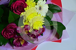 Close-up colorful spring bouquet with many different flowers jelly and white chrysanthemums, burgundy red roses