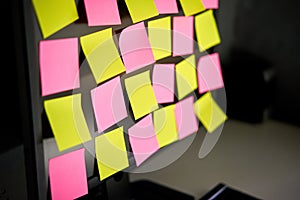 Close up colorful sticky notes reminders on computer monitor