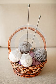 Close-up of colorful wool balls and giant knitting needles in a basket photo