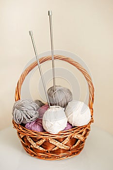 Close-up of colorful wool balls and giant knitting needles in a basket photo