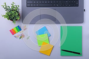 Close-up of comfortable working place in office with laptop, notebook, glasses, pen and other equipment laying on table