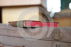 Close-up composition of the spine of a book lying on an old suitcase