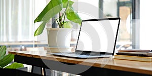 Close up computer laptop with white screen on wood table in modern office