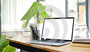 Close up computer laptop with white screen on wood table in modern office