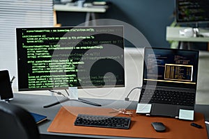 Close up of Computer Monitor and Laptop Displaying Programming Code in Office