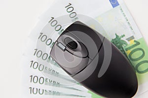 Close up of computer mouse and euro money